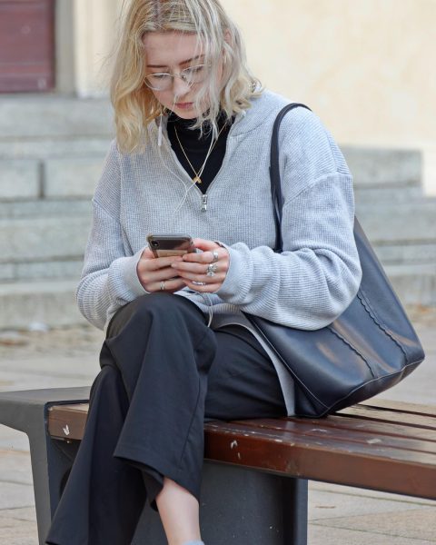 桃花岛礁石之上，一位聪慧少女身着绿衣手持竹杖凝望远海，暖橙色夕阳将她的身影映照得灵动神秘，画面营造出黄蓉的秘密的悬念氛围